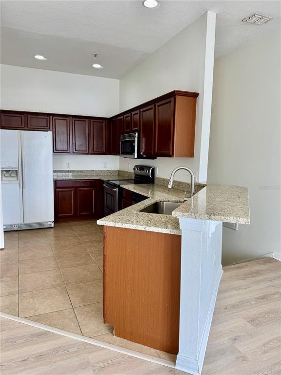 6404 South Goldenrod Road, Unit 2A Orlando, FL 32822 - Photo 9 of 40 a kitchen with stainless steel appliances granite countertop a sink counter space and cabinets