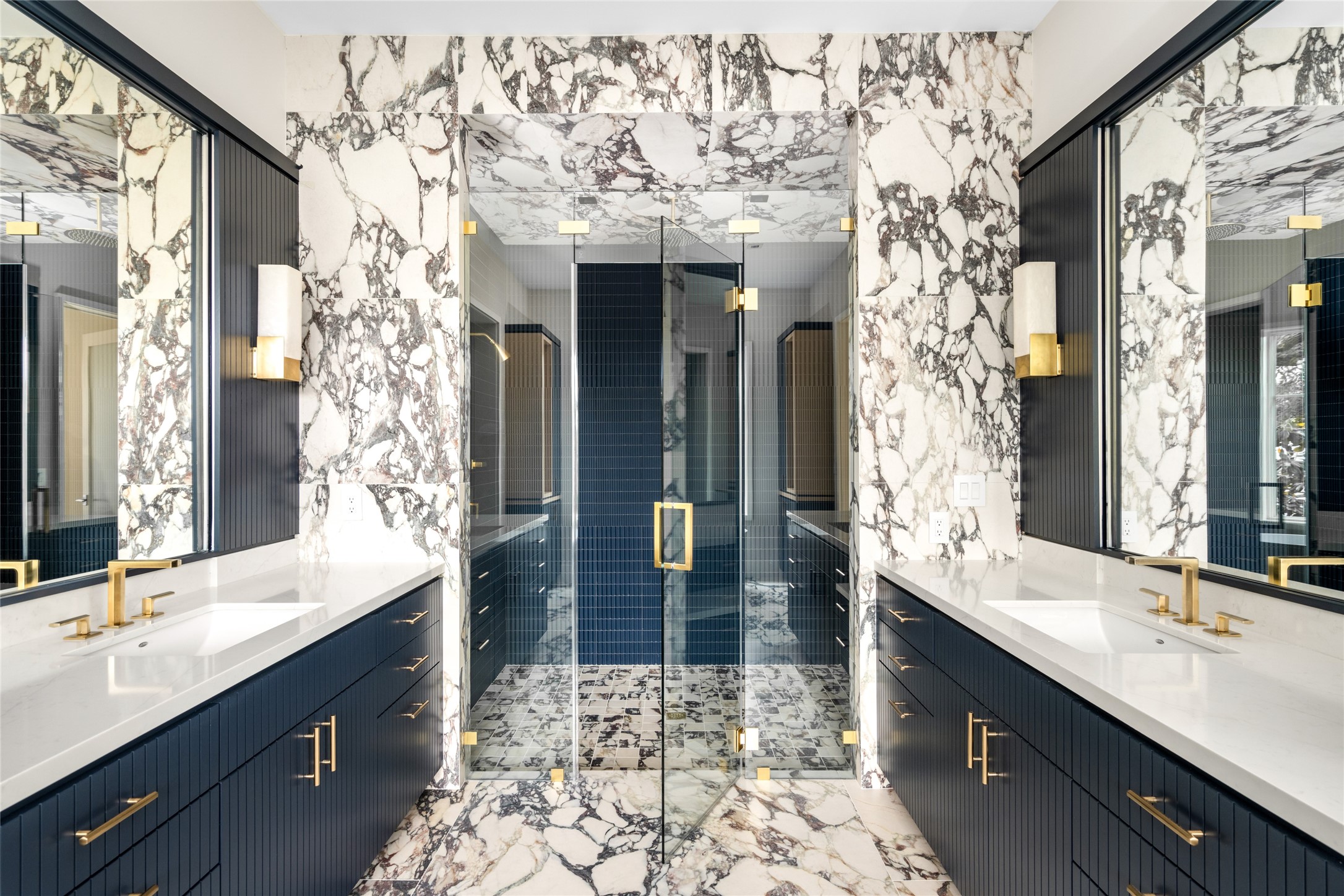 4006 Overbrook Lane Houston, TX 77027 - Photo 30 of 50 An elevated primary bath anchored by dual vanities & bold surfaces, paired with fluted navy cabinetry and layered brass details for a polished look.