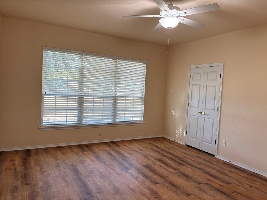 318 Crockett Loop Georgetown, TX 78633 - Photo 15 of 29 an empty room with wooden floor fan and windows