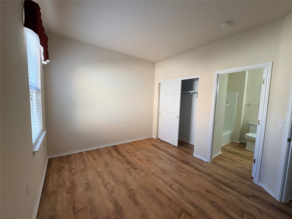 318 Crockett Loop Georgetown, TX 78633 - Photo 19 of 29 a view of an empty room with wooden floor and a bathroom