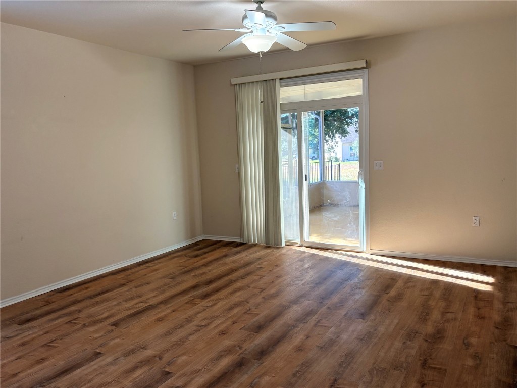 318 Crockett Loop Georgetown, TX 78633 - Photo 6 of 29 a view of an empty room with wooden floor and a window