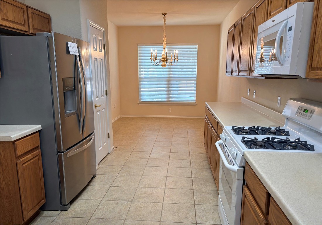 318 Crockett Loop Georgetown, TX 78633 - Photo 7 of 29 a kitchen with stainless steel appliances granite countertop a refrigerator and a stove top oven