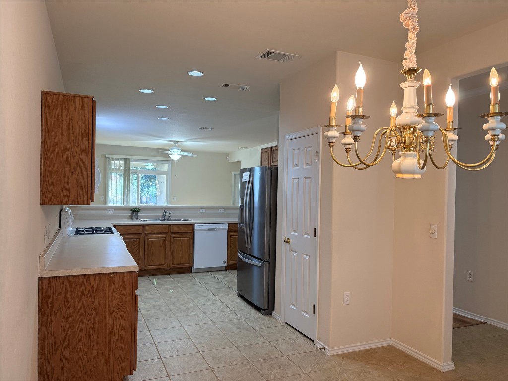 318 Crockett Loop Georgetown, TX 78633 - Photo 9 of 29 a large kitchen with stainless steel appliances a refrigerator and a stove top oven