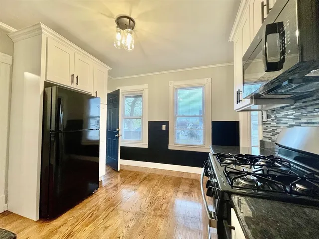 a kitchen with stainless steel appliances granite countertop a refrigerator and a stove
