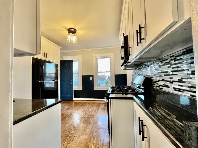 a kitchen with kitchen island a counter top space a sink a refrigerator and a stove