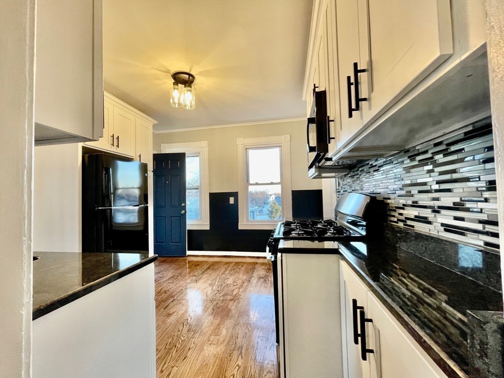 119 Revere Street, Unit 3 Springfield, MA 01108 - Photo 16 of 16 a kitchen with kitchen island a counter top space a sink a refrigerator and a stove