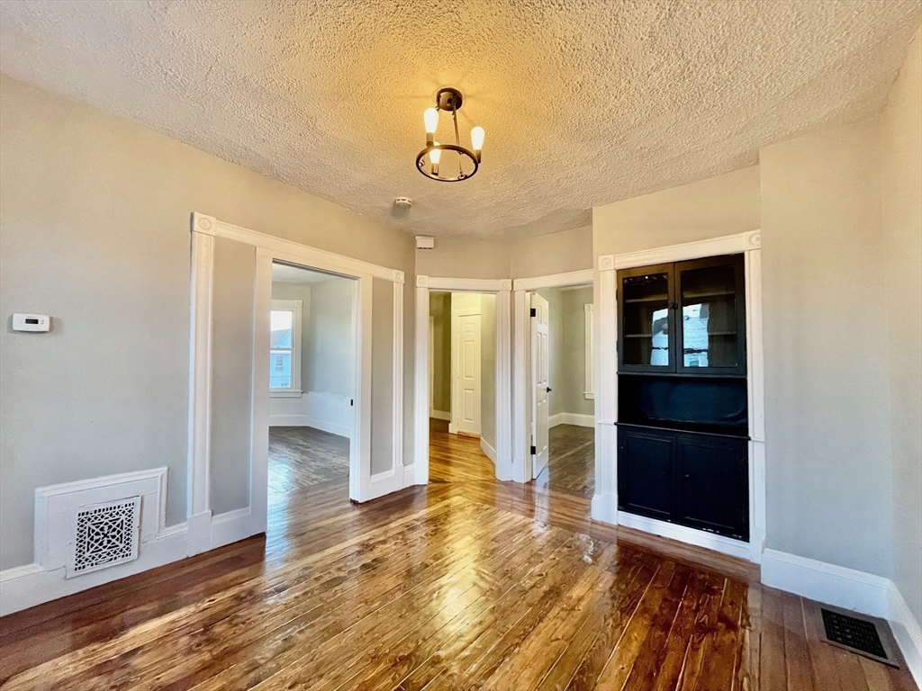 119 Revere Street, Unit 3 Springfield, MA 01108 - Photo 7 of 16 a view of an empty room with wooden floor and a window