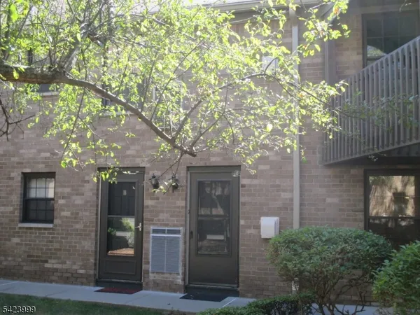 a front view of a house with a tree