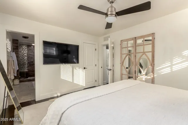 a bedroom with a bed tv and a window