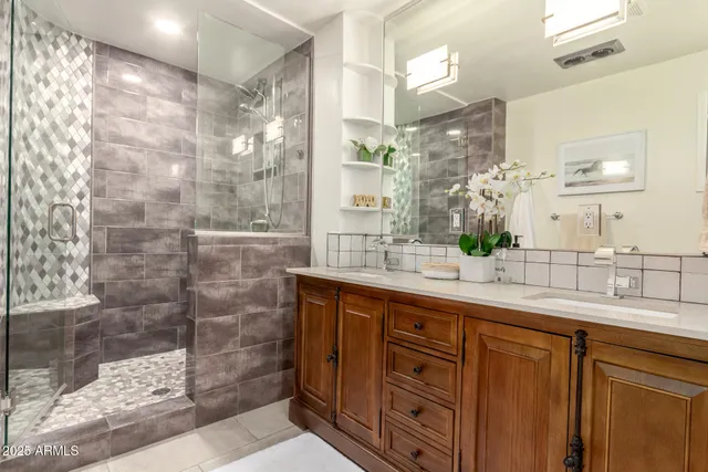 a bathroom with a granite countertop sink mirror and shower