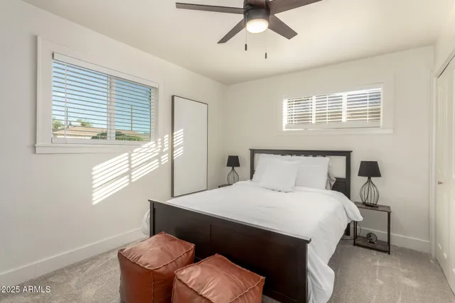 a bedroom with a bed window and a chandelier