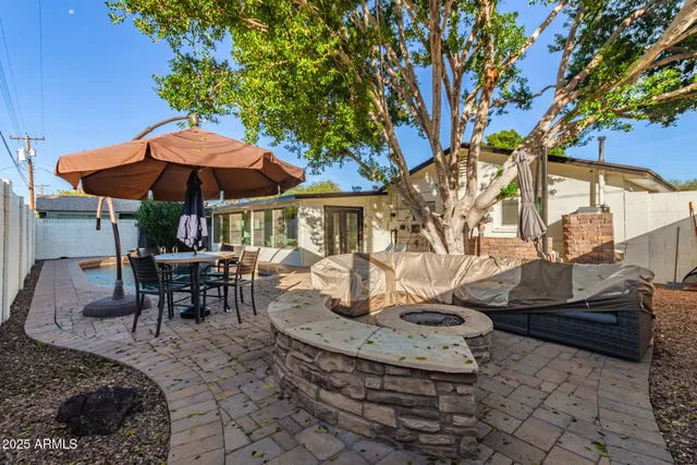 a view of a patio with table and chairs under an umbrella