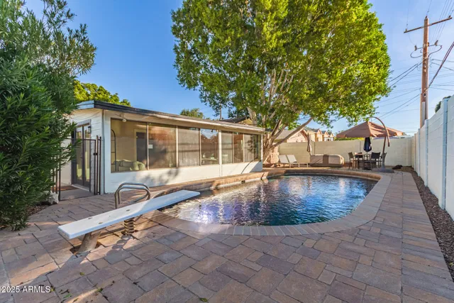 a view of a house with swimming pool and sitting area