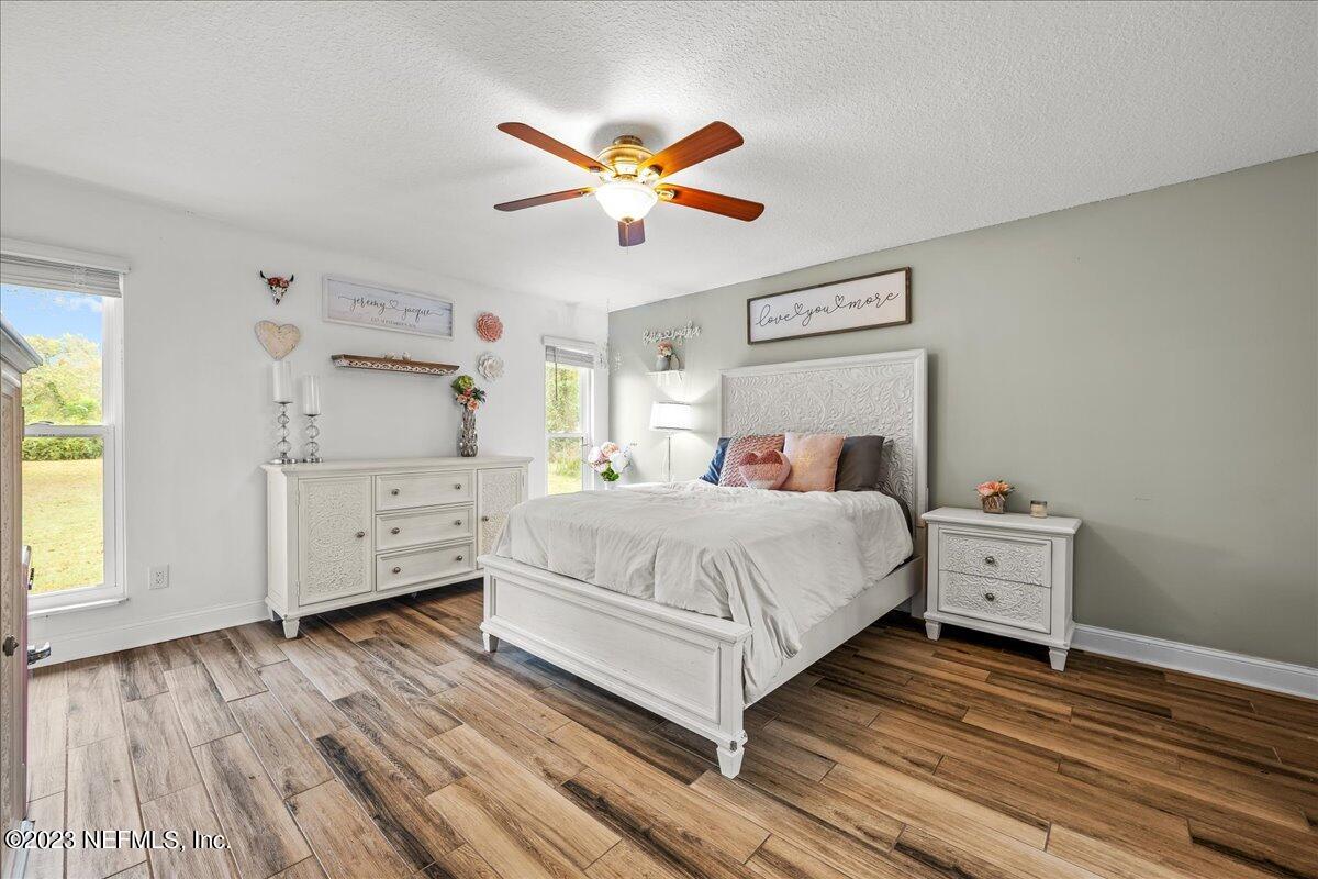 4755 Leopard Circle Middleburg, FL 32068 - Photo 13 of 38 a bedroom with a large bed and a chandelier