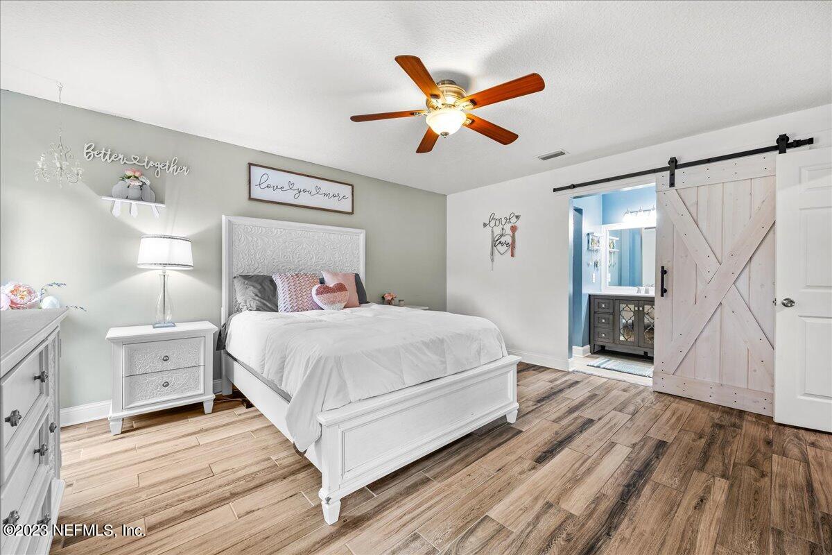 4755 Leopard Circle Middleburg, FL 32068 - Photo 14 of 38 a bedroom with a large bed and a chandelier