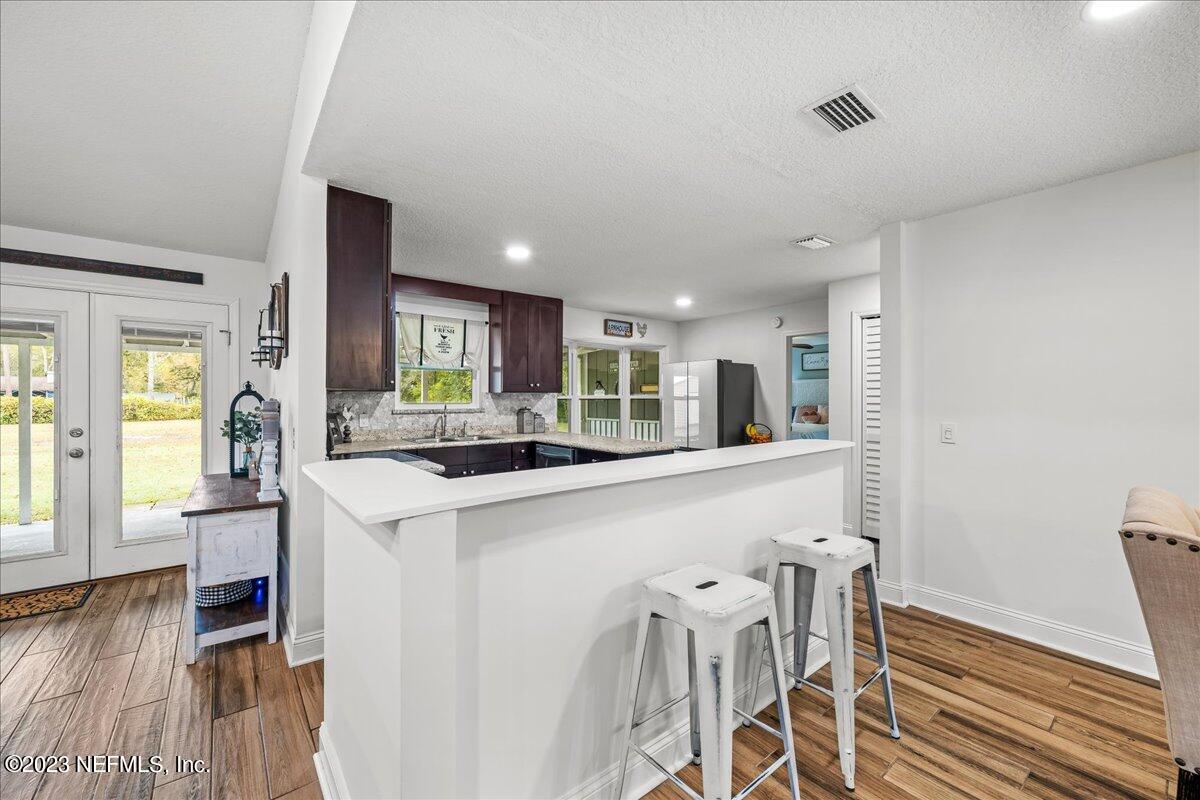 4755 Leopard Circle Middleburg, FL 32068 - Photo 9 of 38 a kitchen with table chairs refrigerator and wooden floor
