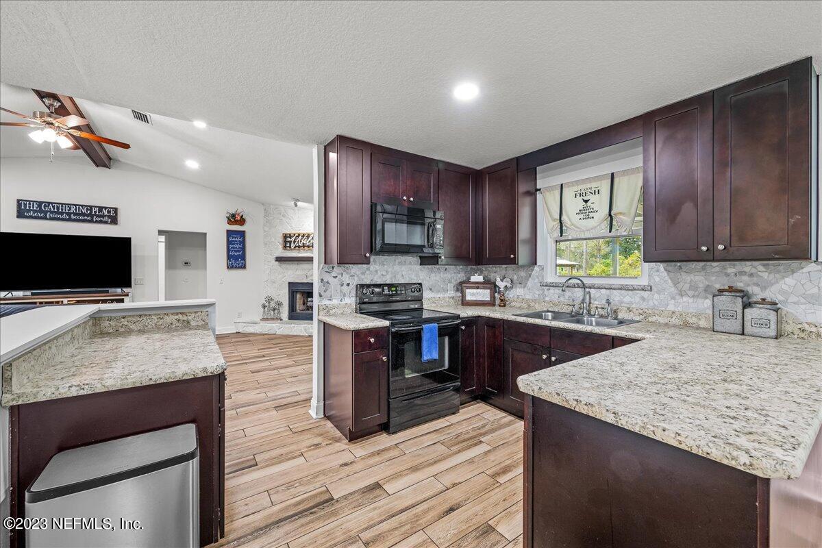 4755 Leopard Circle Middleburg, FL 32068 - Photo 10 of 38 a kitchen with stainless steel appliances granite countertop wooden cabinets a stove top oven a sink and dishwasher