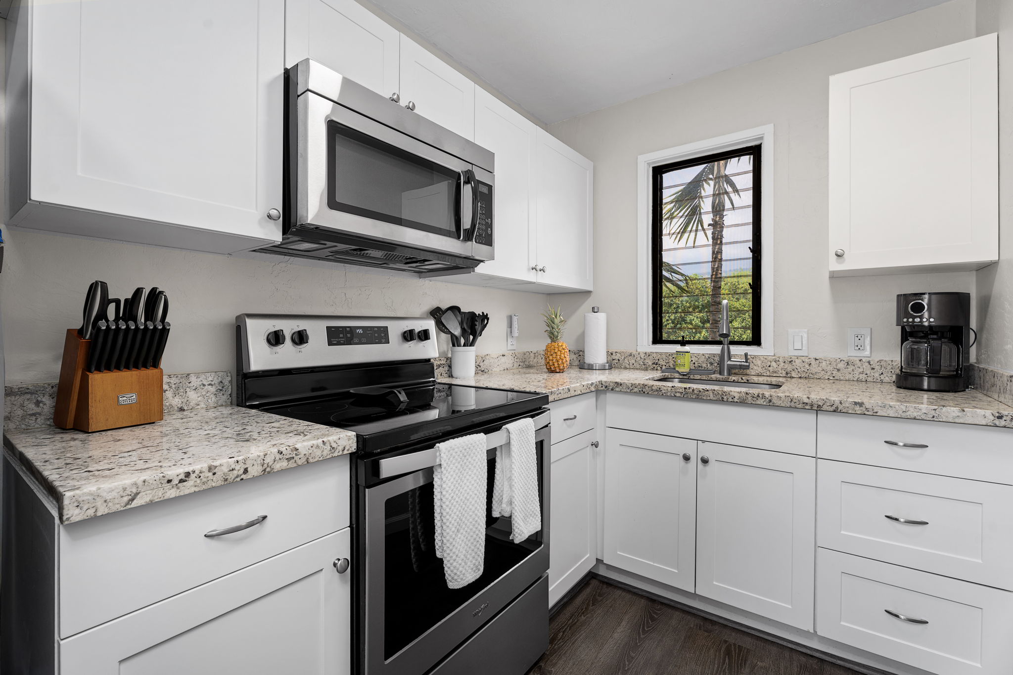 76-6233 Alii Drive, Unit 264 Kailua-Kona, HI 96740 - Photo 7 of 17 a kitchen with granite countertop white cabinets stainless steel appliances and a sink