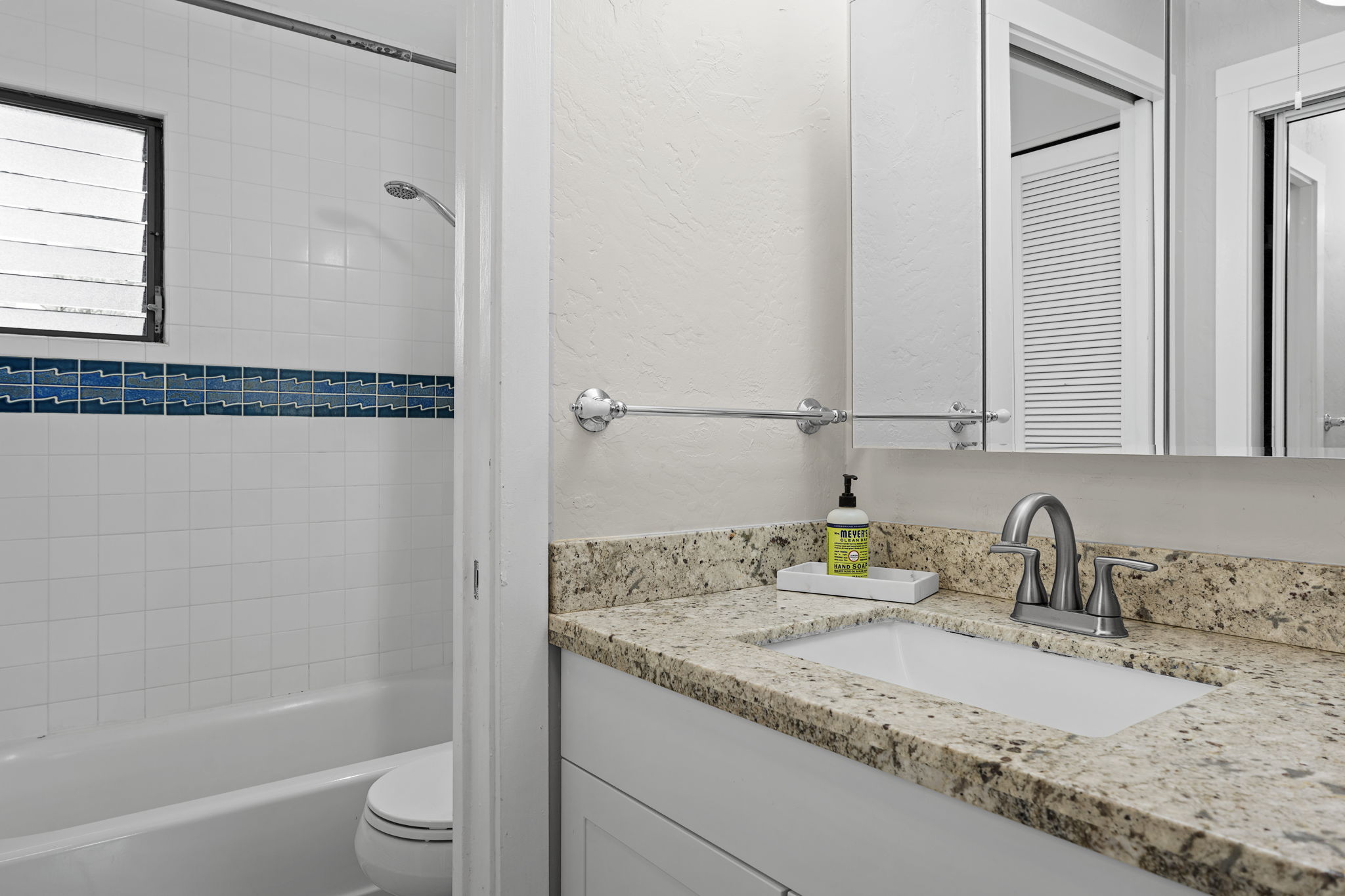 76-6233 Alii Drive, Unit 264 Kailua-Kona, HI 96740 - Photo 9 of 17 a bathroom with a granite countertop sink a toilet and shower
