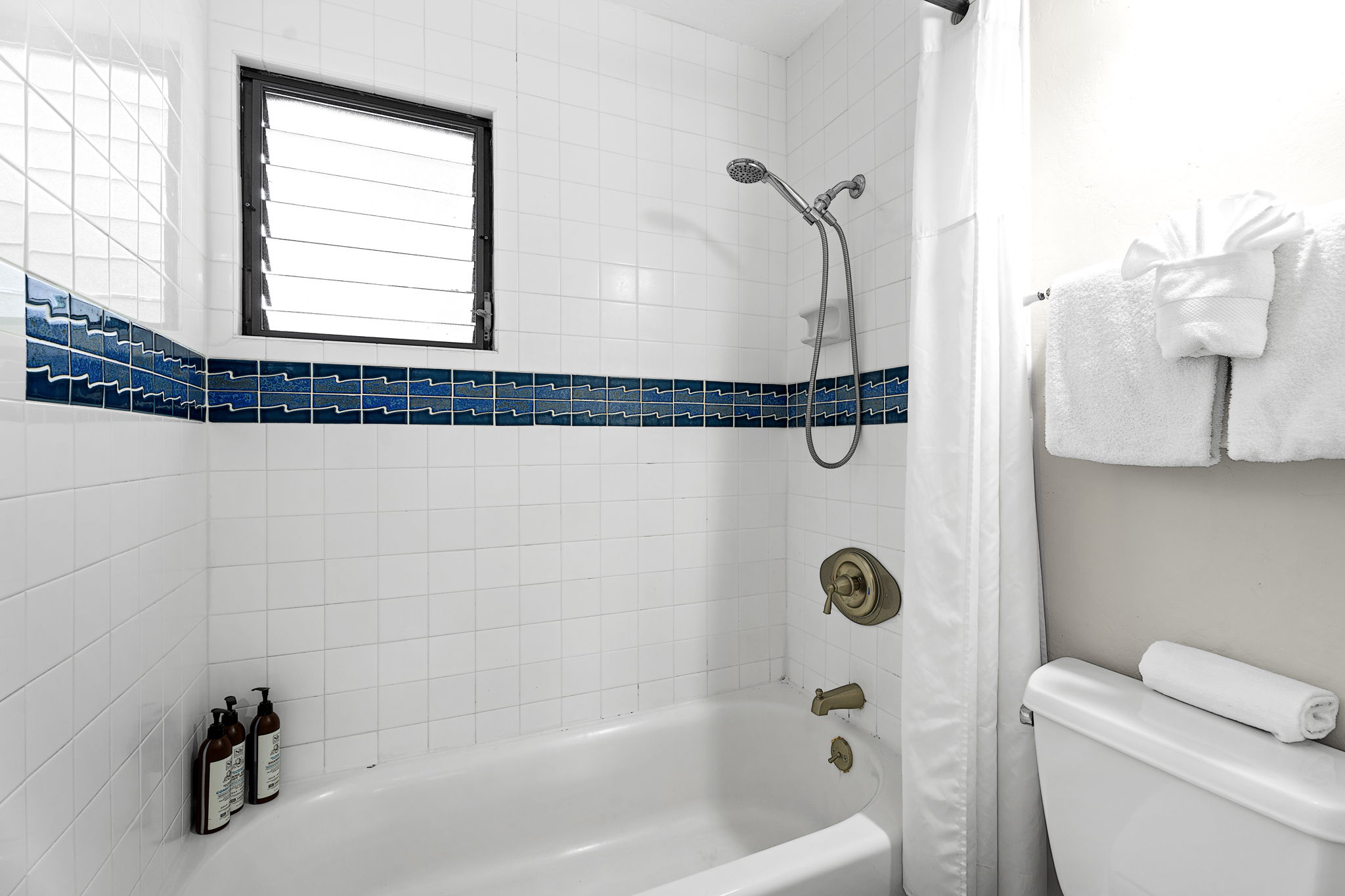 76-6233 Alii Drive, Unit 264 Kailua-Kona, HI 96740 - Photo 10 of 17 a bathroom with a shower a toilet and a window