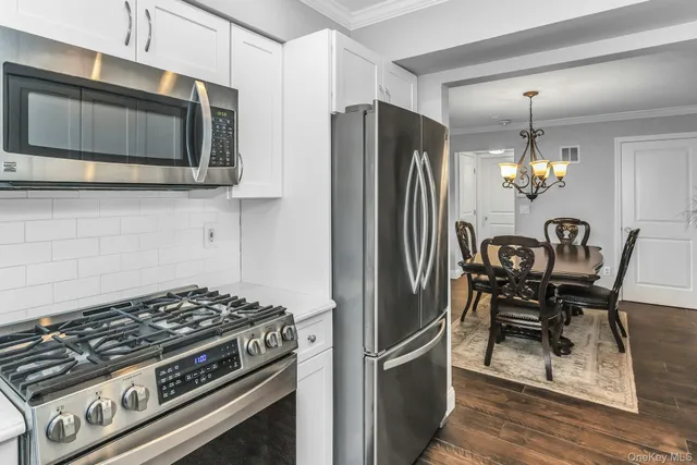 a kitchen with stainless steel appliances granite countertop a stove a refrigerator and a microwave