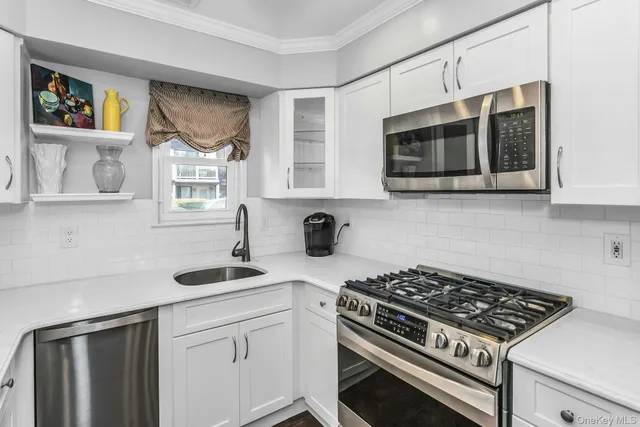 a kitchen with stainless steel appliances a stove a microwave and sink