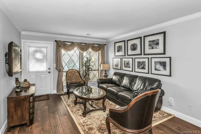 a living room with furniture a flat screen tv and a window