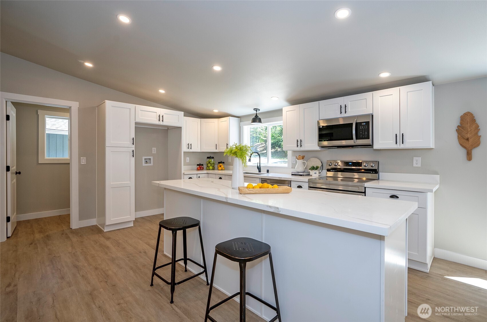 22902 Keating Road Orting, WA 98360 - Photo 13 of 40 a kitchen with stainless steel appliances a microwave a stove a sink dishwasher a refrigerator white cabinets and wooden floor