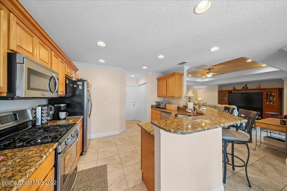 5265 Evinrude Road Melbourne, FL 32934 - Photo 13 of 42 a kitchen with sink stove and cabinets