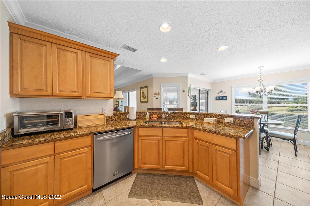 5265 Evinrude Road Melbourne, FL 32934 - Photo 14 of 42 a kitchen with stainless steel appliances granite countertop a sink and cabinets
