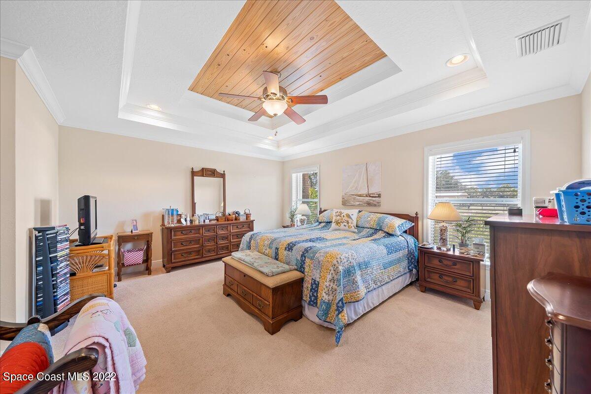 5265 Evinrude Road Melbourne, FL 32934 - Photo 16 of 42 a bedroom with a bed and wooden cabinets