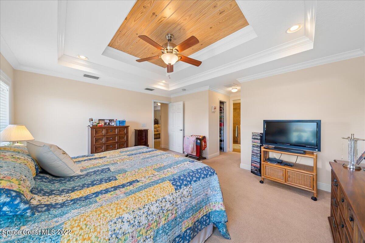 5265 Evinrude Road Melbourne, FL 32934 - Photo 17 of 42 a bedroom with a bed and a flat screen tv