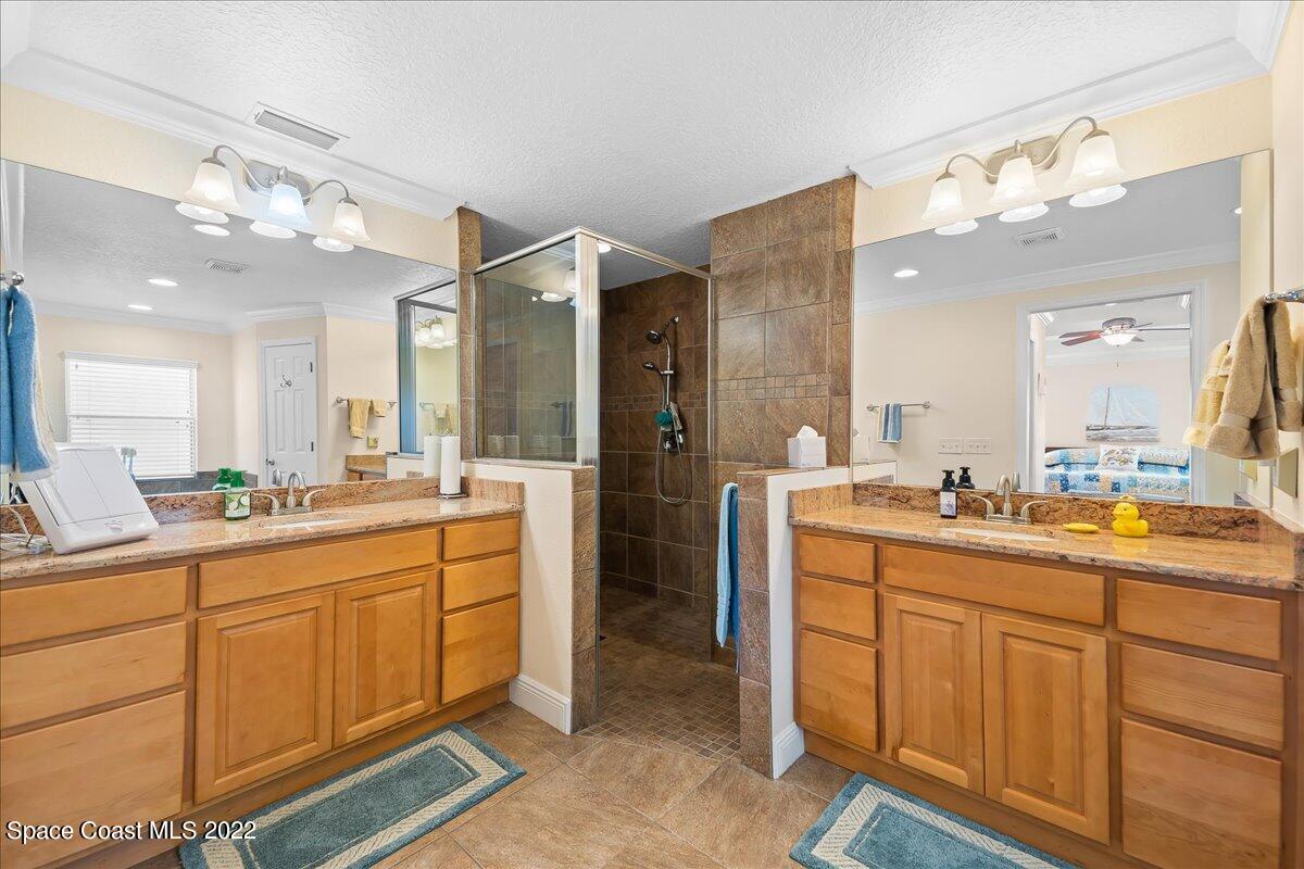 5265 Evinrude Road Melbourne, FL 32934 - Photo 18 of 42 a large bathroom with a double vanity sink and a mirror