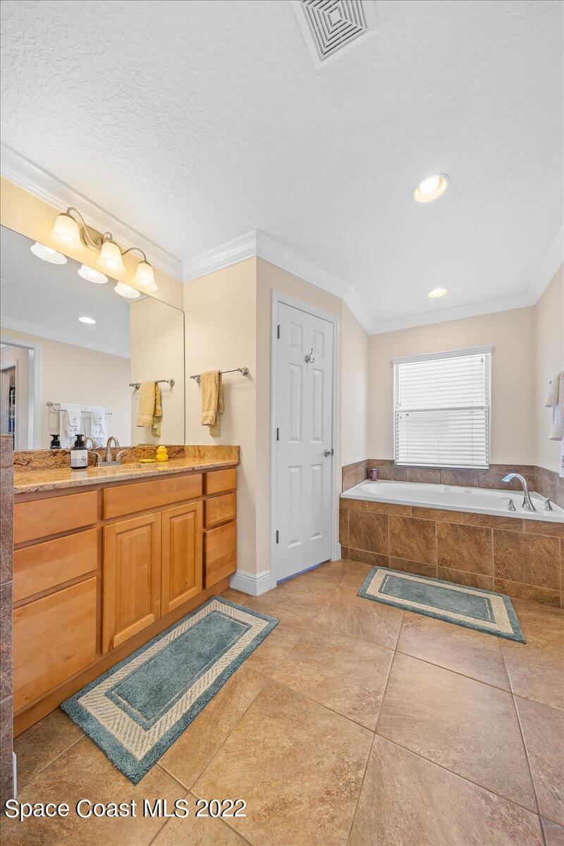 5265 Evinrude Road Melbourne, FL 32934 - Photo 19 of 42 a spacious bathroom with a tub a sink and a mirror