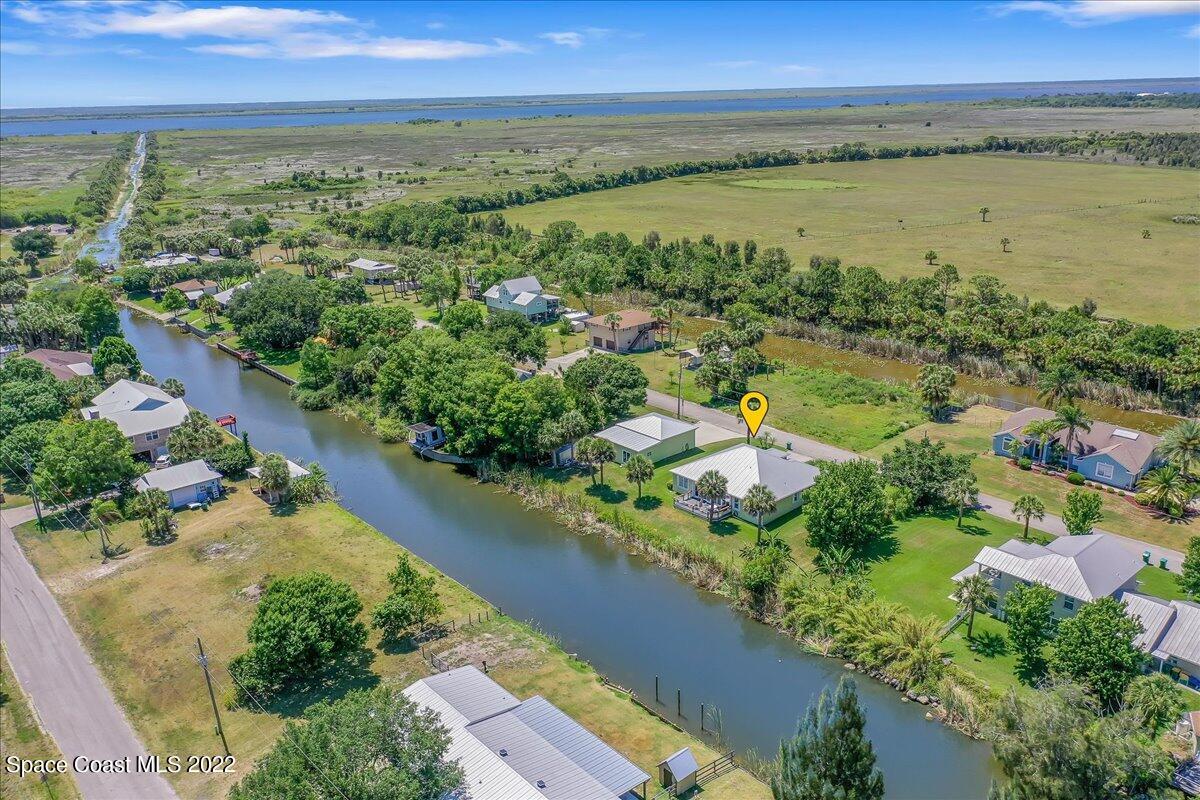 5265 Evinrude Road Melbourne, FL 32934 - Photo 2 of 42 an aerial view of green landscape with trees houses and lake view