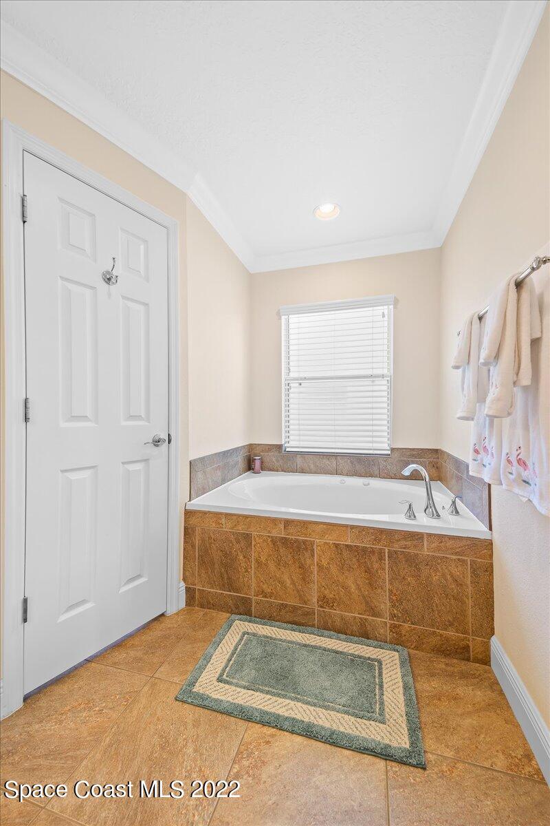 5265 Evinrude Road Melbourne, FL 32934 - Photo 23 of 42 a bathroom with a tub sink and mirror