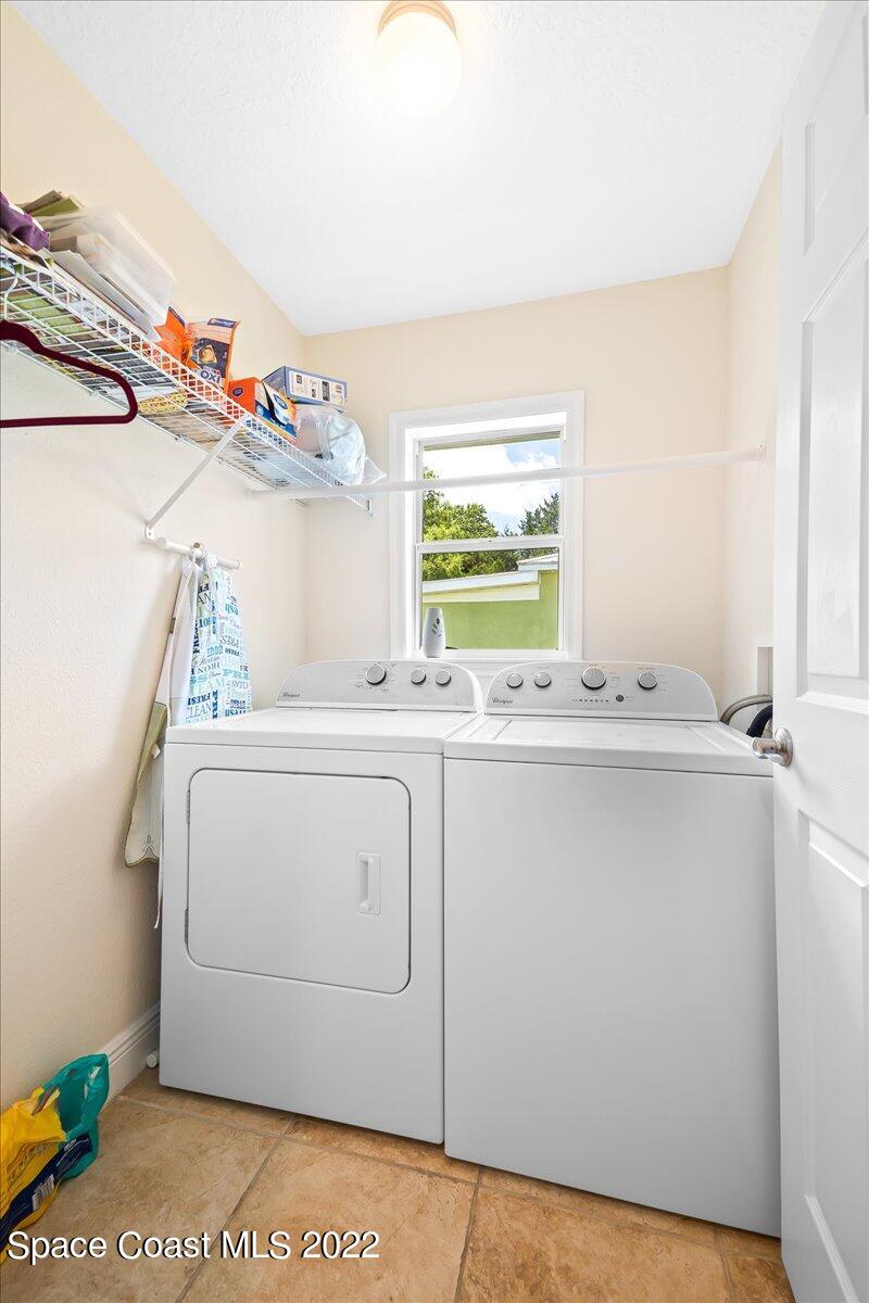 5265 Evinrude Road Melbourne, FL 32934 - Photo 31 of 42 a utility room with cabinets washer and dryer