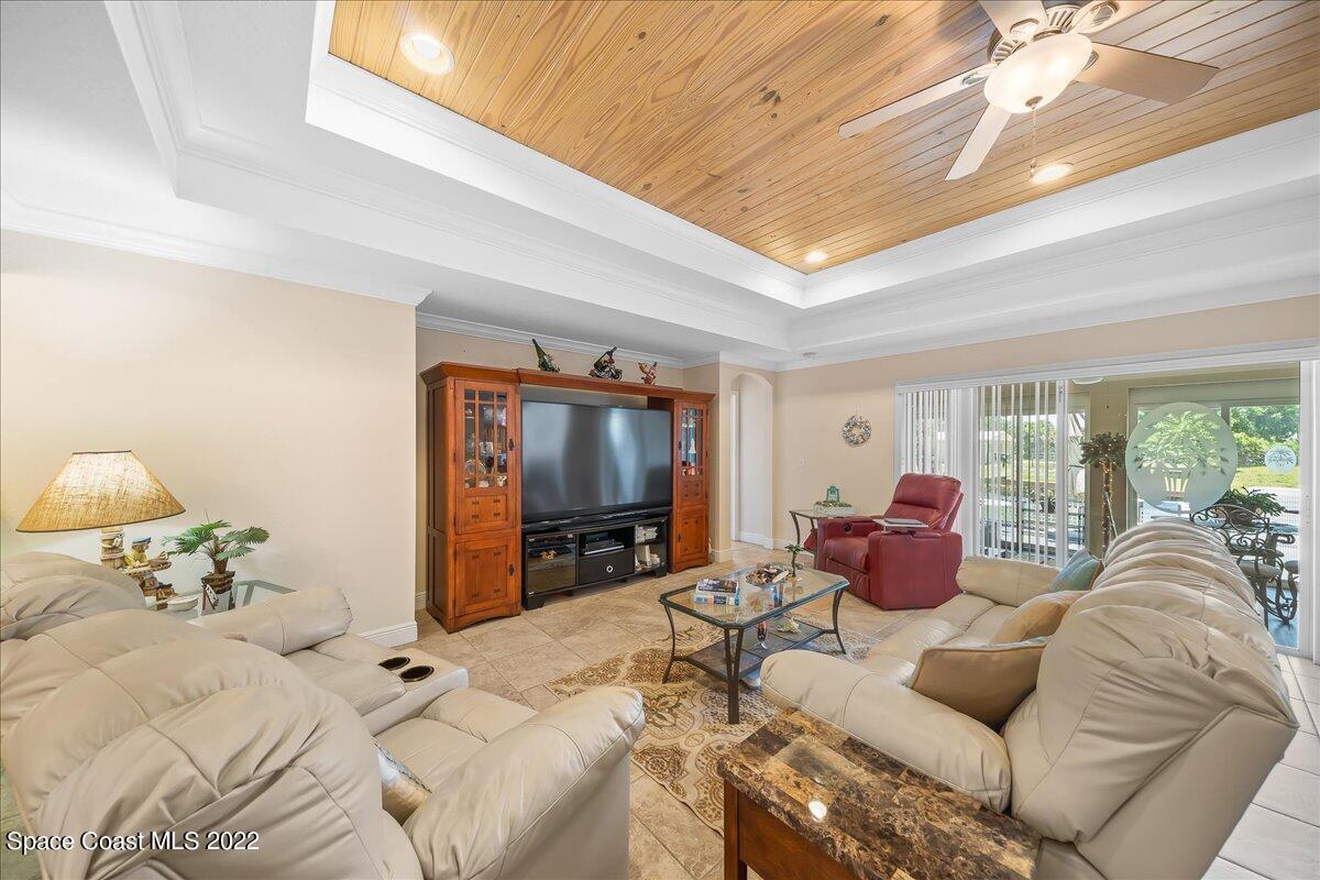 5265 Evinrude Road Melbourne, FL 32934 - Photo 10 of 42 a living room with furniture a large window and a flat screen tv
