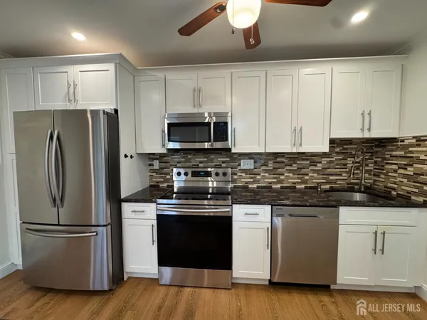 a kitchen with stainless steel appliances a refrigerator stove and microwave