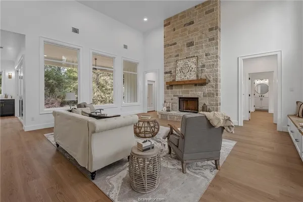 a living room with furniture large window and fireplace