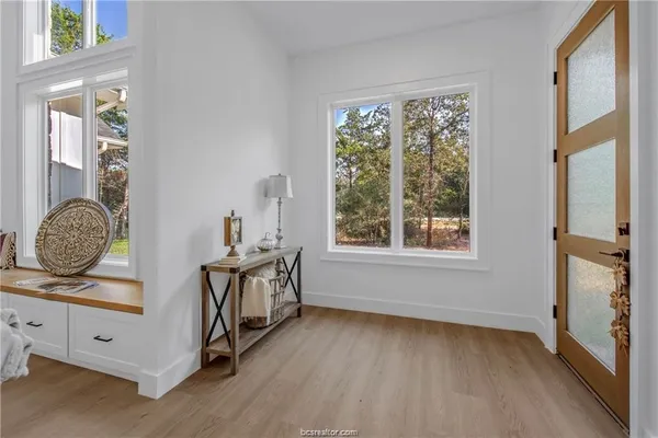 a view of a bedroom with wooden floor and windows