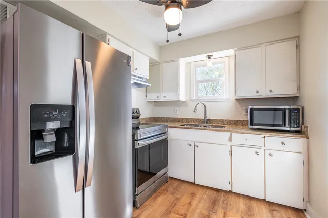 a kitchen with granite countertop cabinets stainless steel appliances and a sink