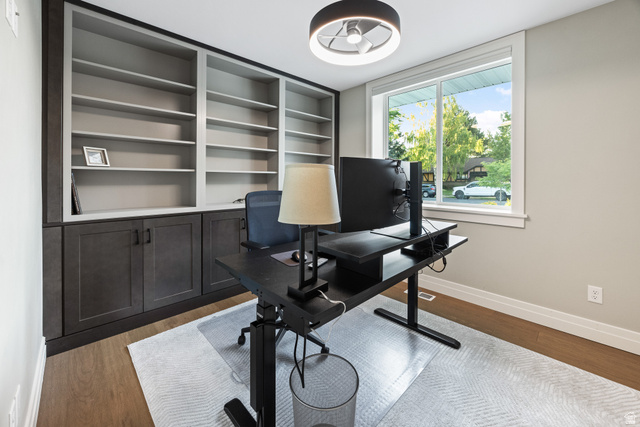 1774 Country Club Drive Logan, UT 84321 - Photo 10 of 28 Room featuring custom built-in shelving with lower cabinetry, wood-finish flooring, and a large window