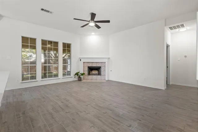 a view of an empty room with a fireplace and a window