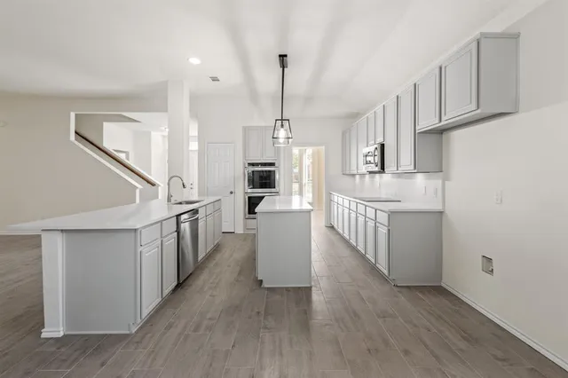 a kitchen with sink cabinets and wooden floor