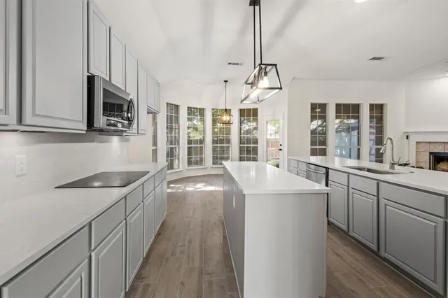 a kitchen with stainless steel appliances granite countertop a sink stove and microwave