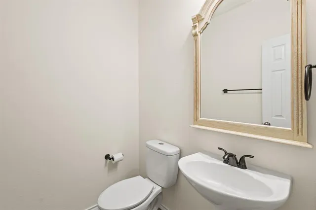 a bathroom with a sink a toilet and mirror
