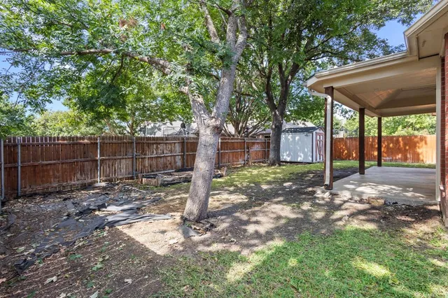 a view of a white house with a large windows and large tree