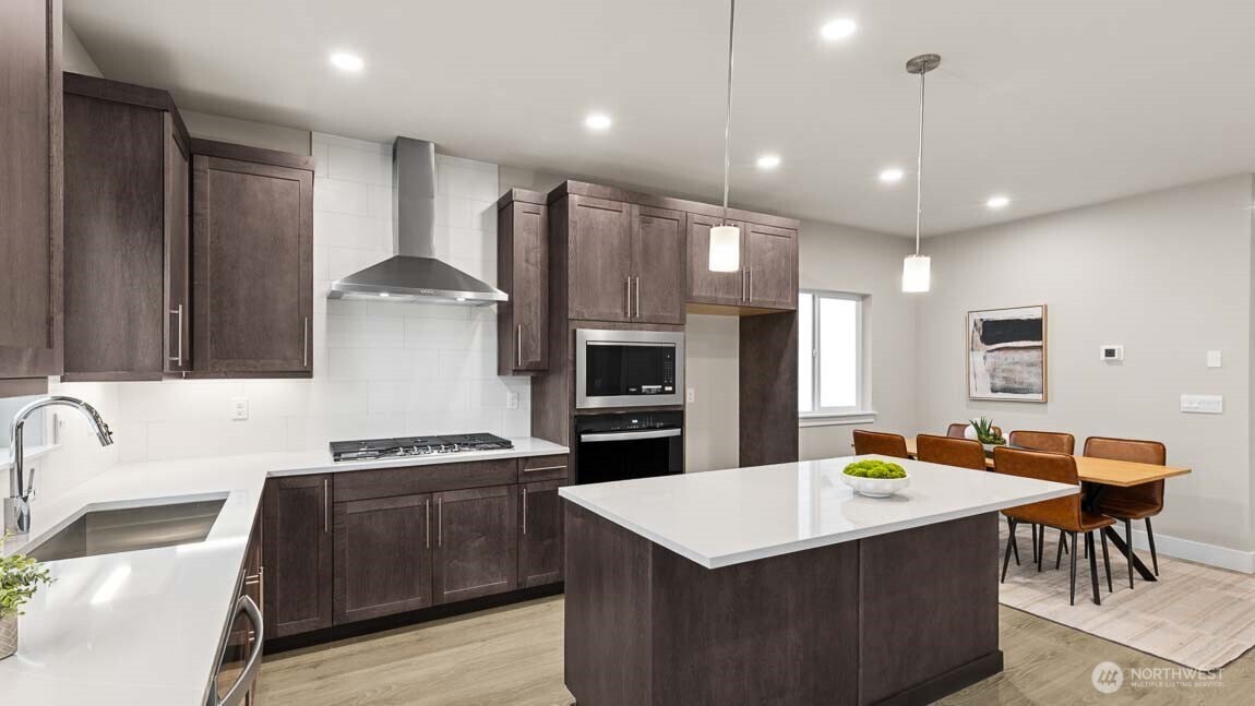 3125 194th Street Southeast Bothell, WA 98012 - Photo 7 of 25 a kitchen with stainless steel appliances kitchen island granite countertop a sink a stove and a refrigerator
