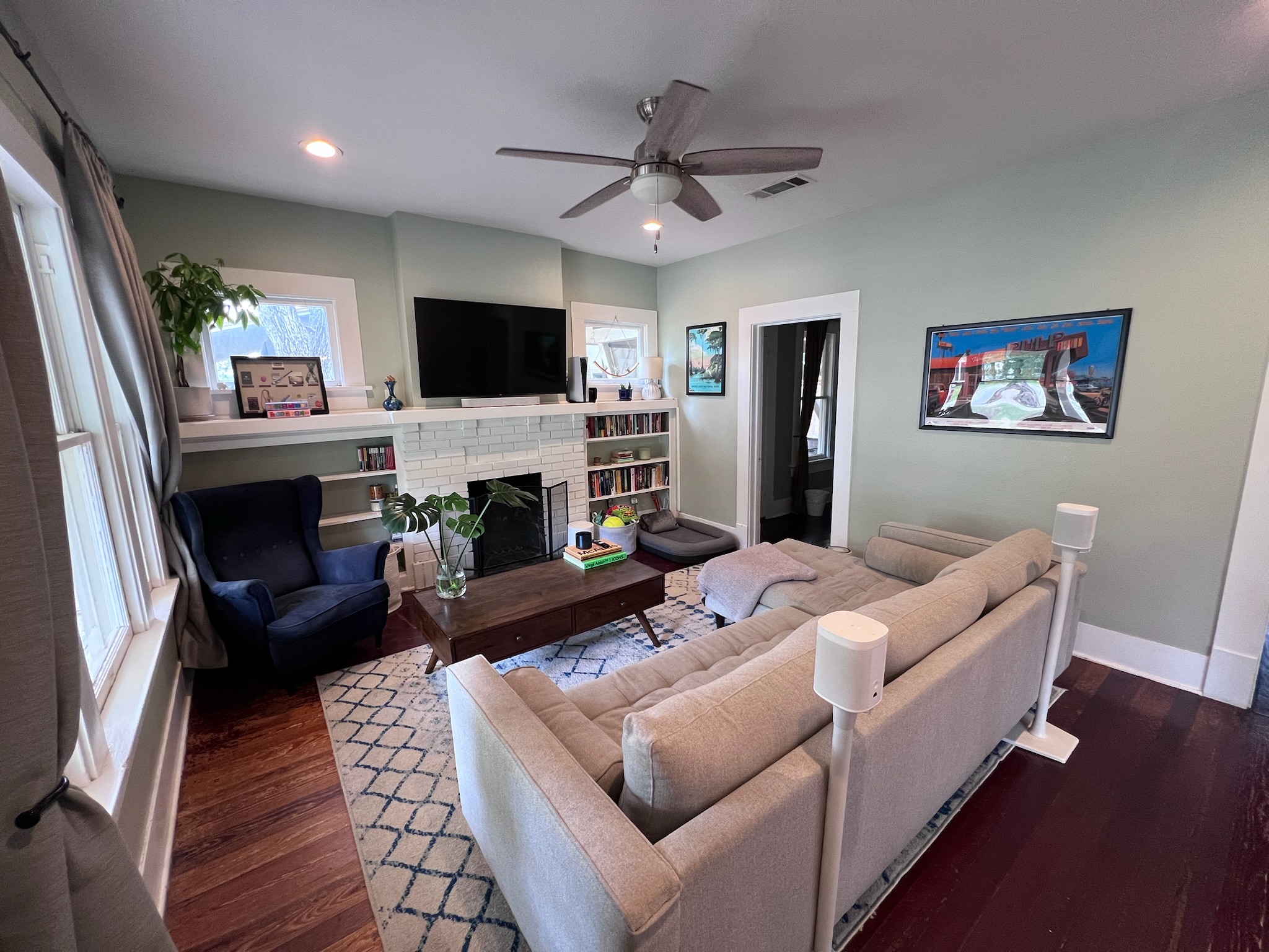 307 East 35th Street, Unit A Austin, TX 78705 - Photo 7 of 31 A well-lit living space features rich hardwood flooring, built-in shelving, and a cozy fireplace, perfect for gatherings.